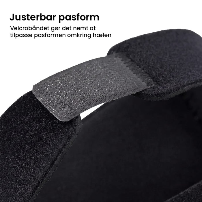Sort hælbeskytter til hælspore med velcrolukning. Pakke med 1 par.