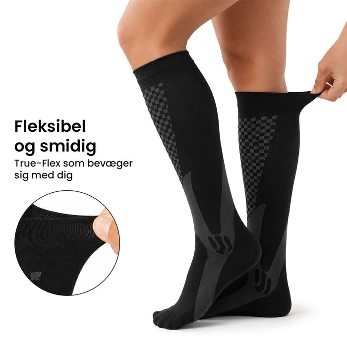 Person iført gråmønstrede kompressionsstrømper til sport, 20–30 mmHg. Det indsatte billede viser stoffets elasticitet.
