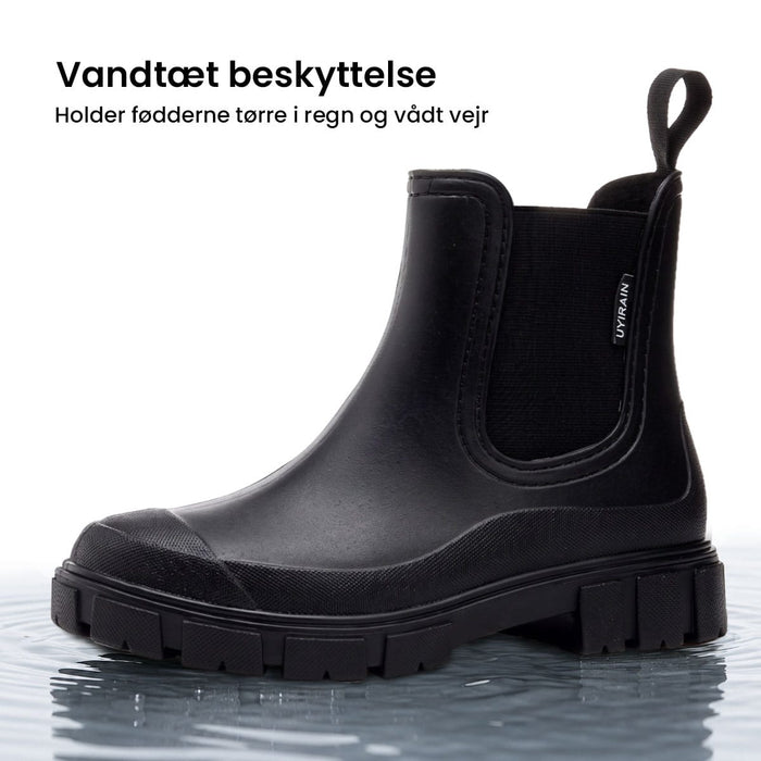 En vandtæt Urban Nordic-støvle med grov sål, der står i lavt vand.