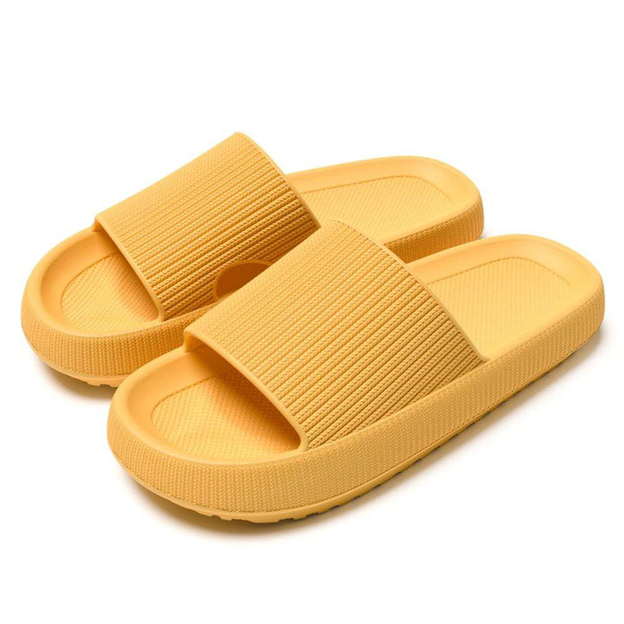Stødabsorberende hjemmesko med memory foam og skridsikre remme, vist på en neutral hvid baggrund.