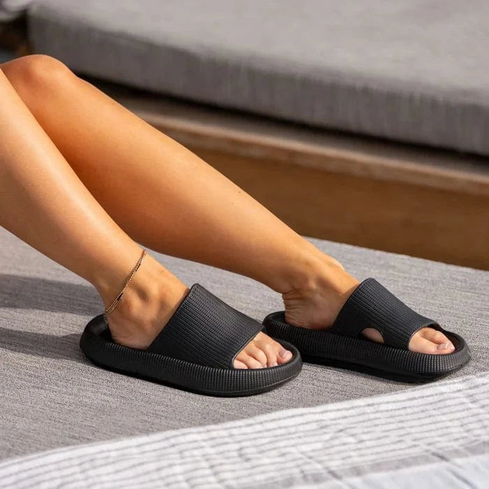 En person slapper af i en udendørs stol med en ankelkæde og behagelige, stødabsorberende tøfler med memory foam.